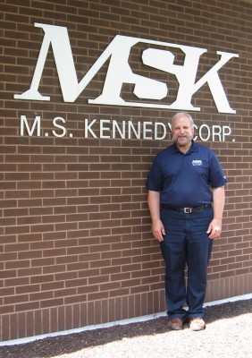 Michael Prockup stands in front of M.S. Kennedy.