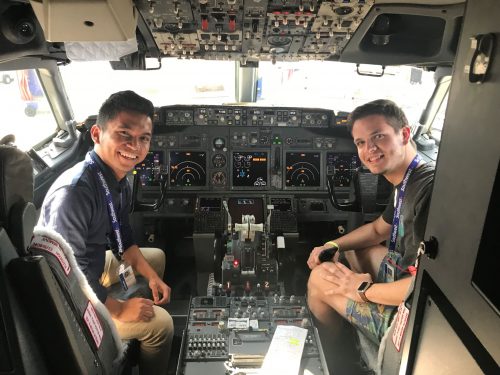 Jez poses in an airplane cockpit.