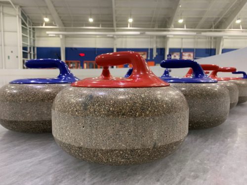 curling stones lined up on the ice at Tennity