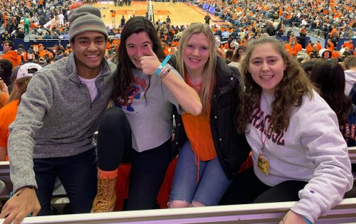 Friends pose together at a men's basketball game