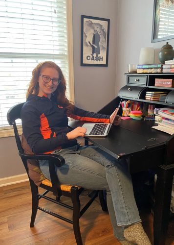 Ava smiles from her desk at home