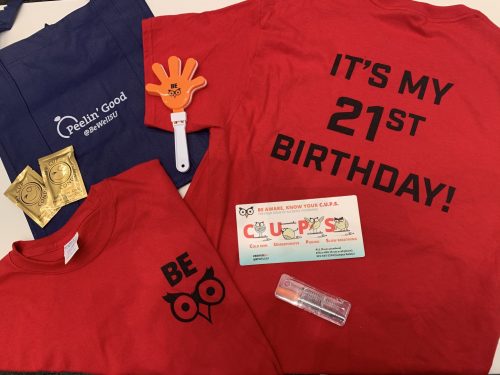 A prize pack including a red t-shirt, hand clapper, tote bag and reusable straw. 