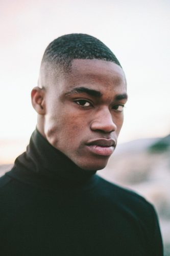 A young man wears a black turtle neck.