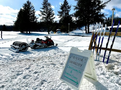 A snowmobile sits in front of a ski rack at the Cross Country Ski Center