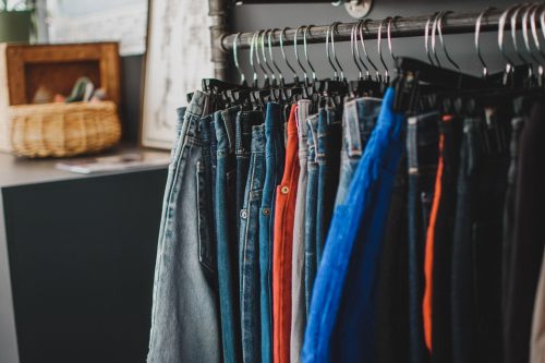 A rack of denim jeans in assorted colors.