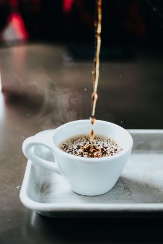 A cup of espresso being poured