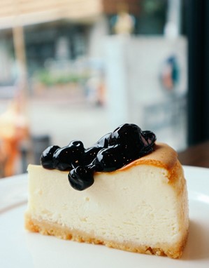 A slice of classic cheesecake with blueberry topping.