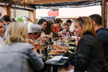 A large group of friends having lunch al fresco. 