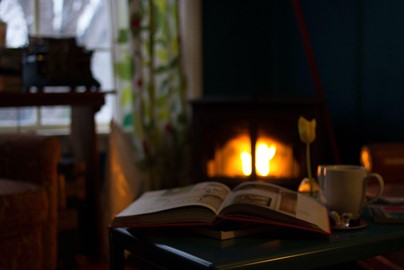 An open book by a fire raging wood stove