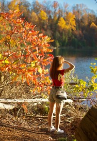 Cecelia leaf peeps at a lake with her hand shielding the sun.