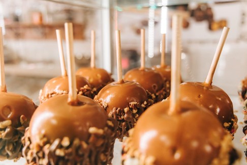 Caramel apples covered in peanuts.