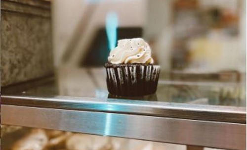 A chocolate cupcake with vanilla frosting sits on the Peoples Place counter.