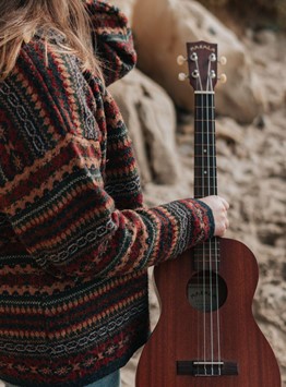 A person holding an acoustic guitar