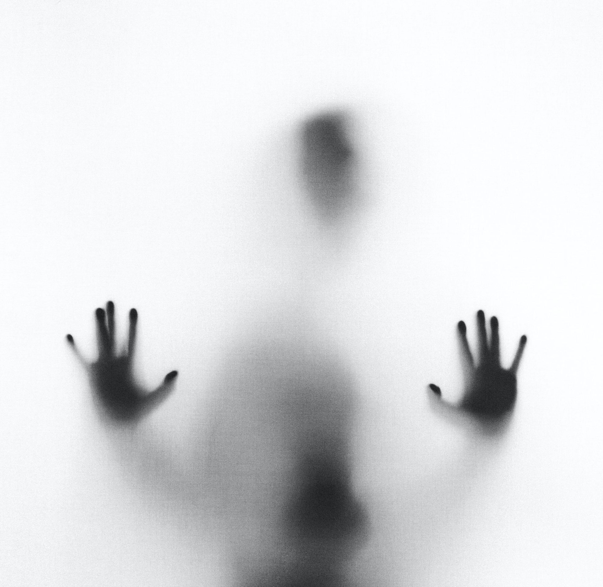 A shadowy figure presses its hands against a translucent fabric