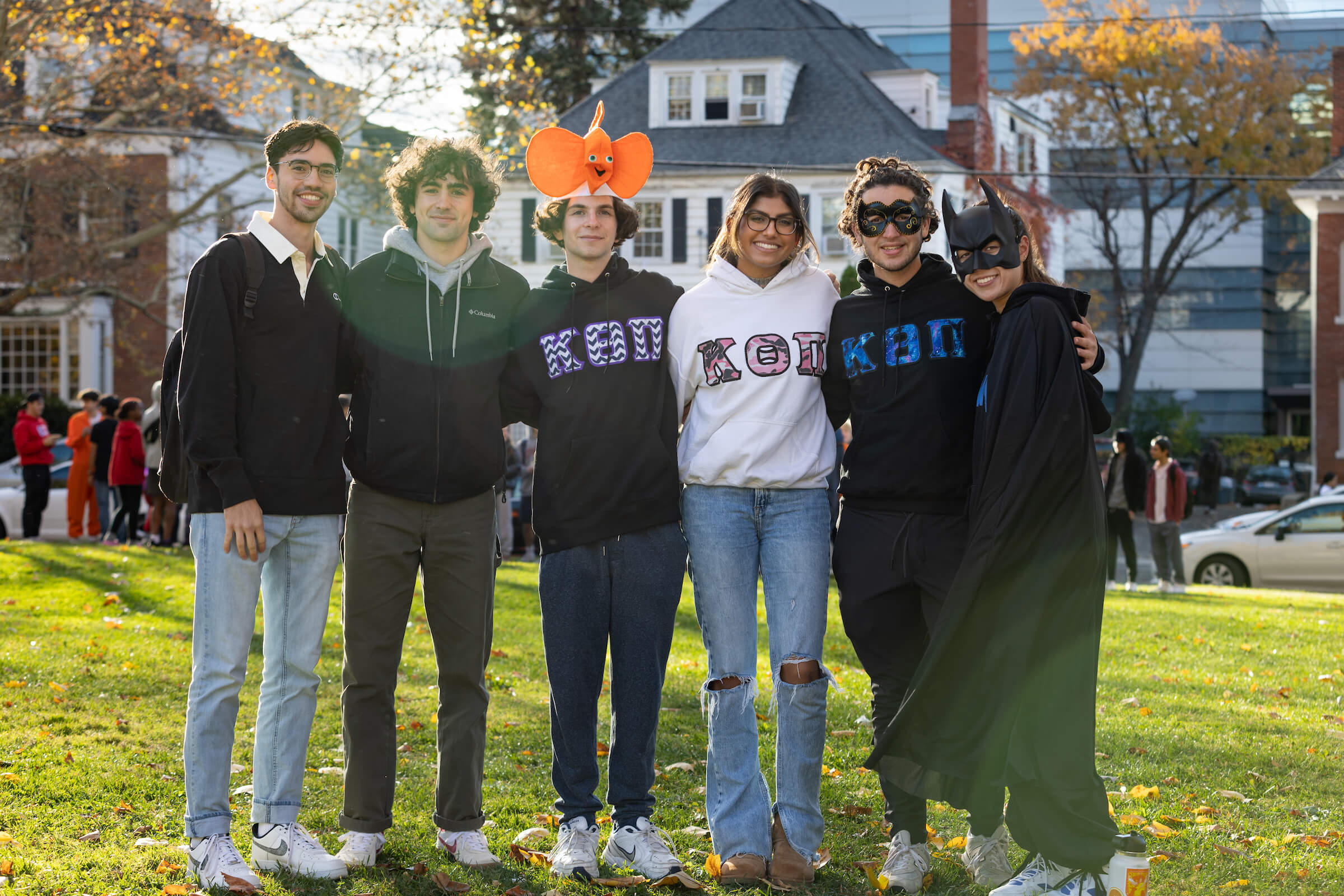 Student members of campus Greek life, some wearing their letters and some wearing Halloween hats and masks, stand together for a photo at the annual Greek or Treat event.