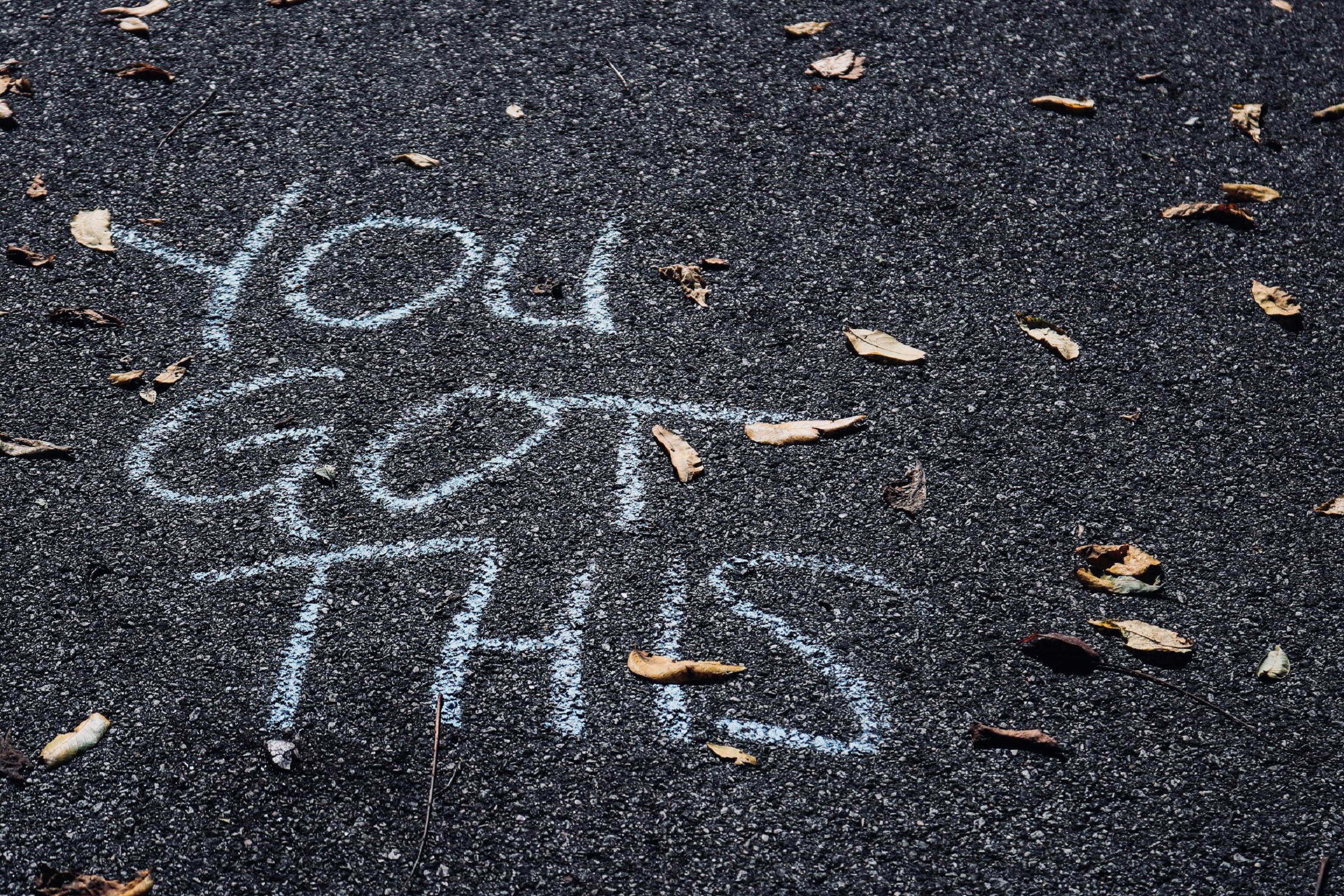 "You got this" written in blue chalk on a road.