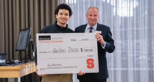 Justin Diaz stands for a photo with his 3rd place winnings from the 2024 Afropreneurship Blackstone LaunchPad competition.