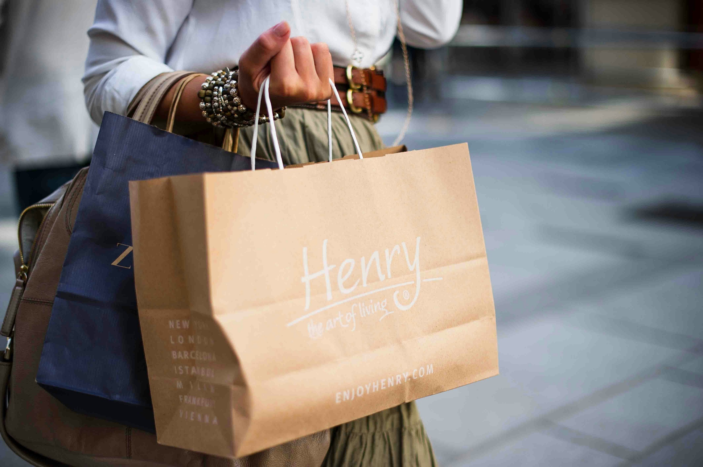 A person holds two shopping bags.
