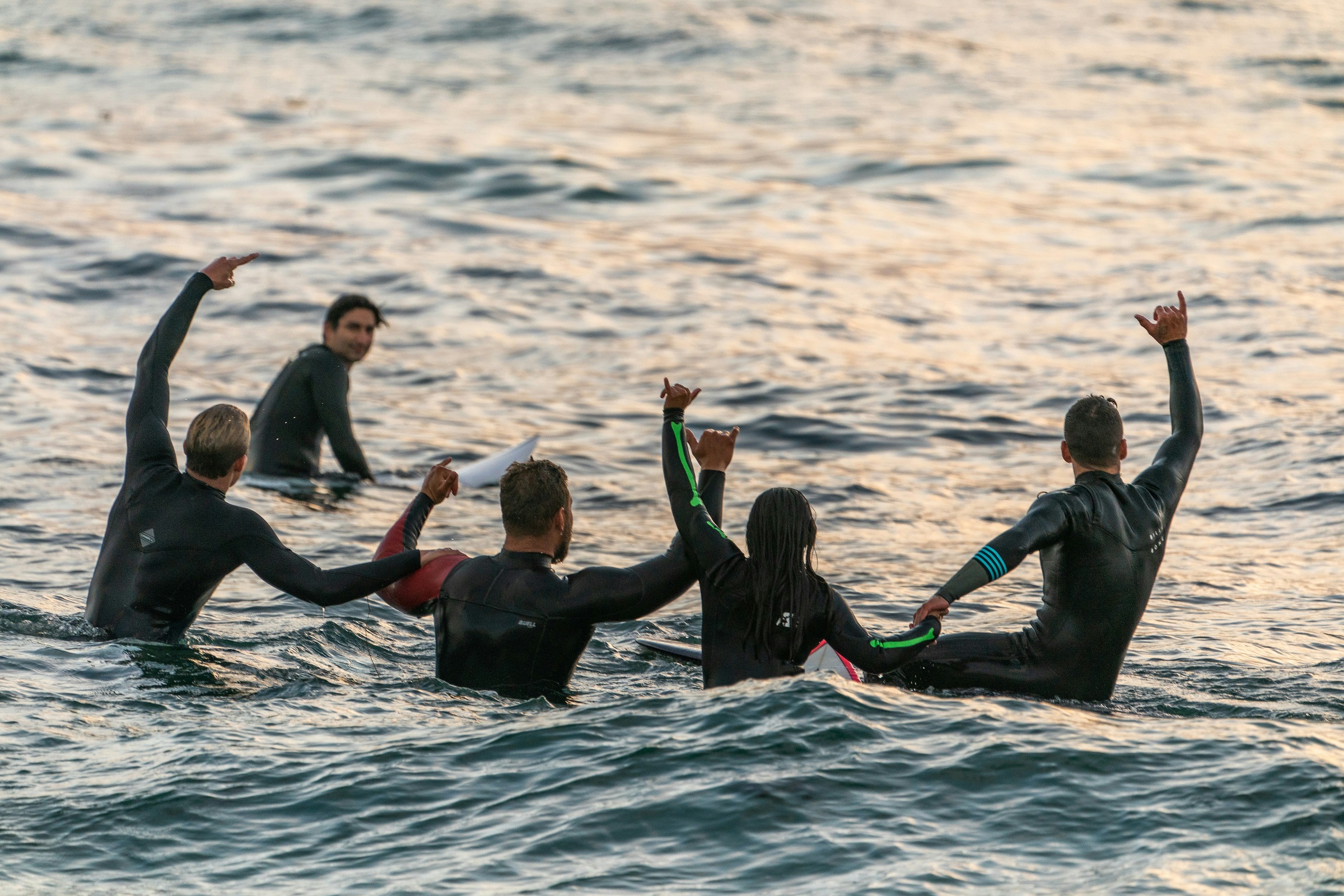 A group of people hang out together on surfboards in the middle of the ocean.