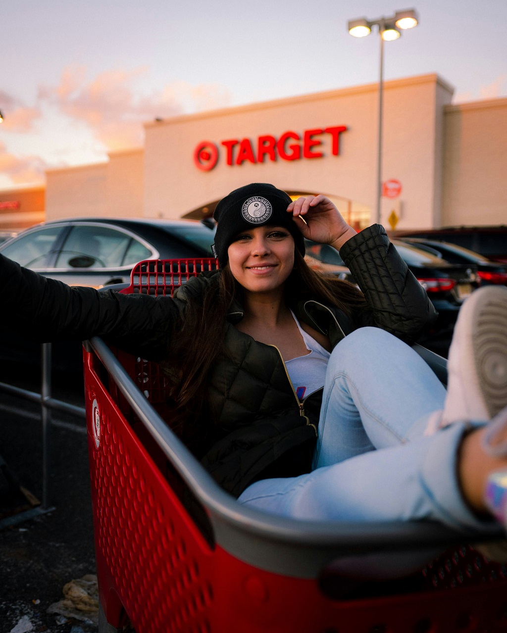 A woman sits in a shopping cart in front of a Target store