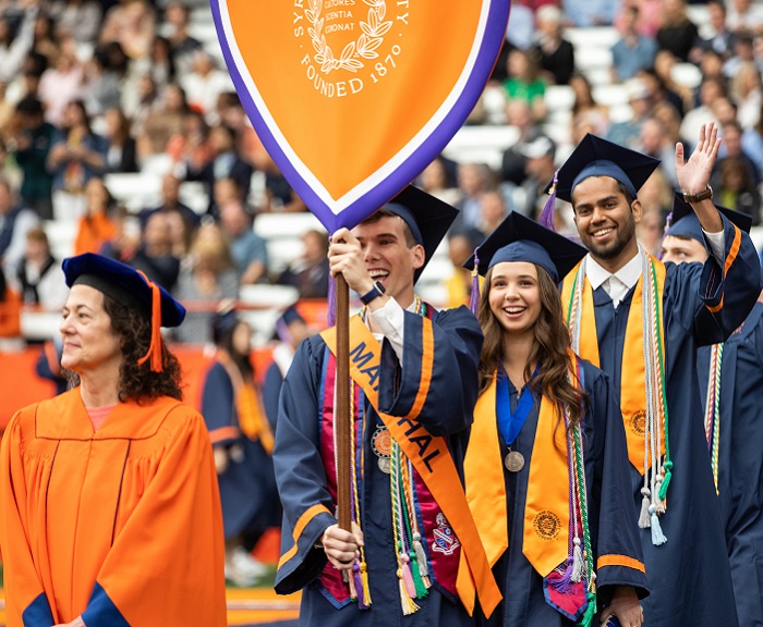 Students process during Commencement, with a Class Marshal wearing his 