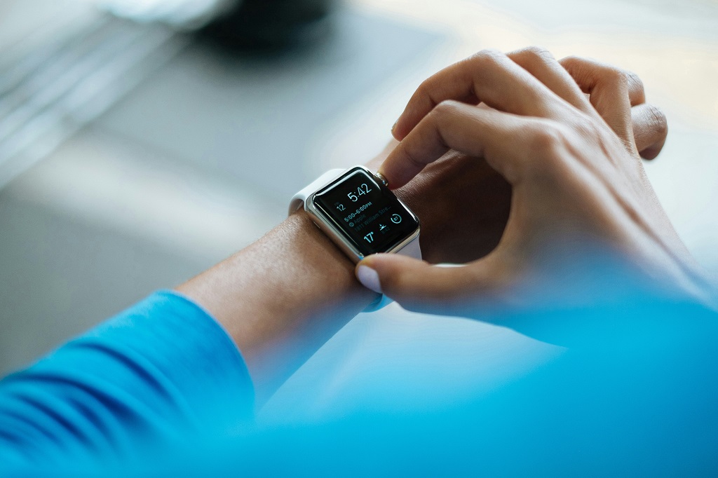 A person adjusts their fitness watch.