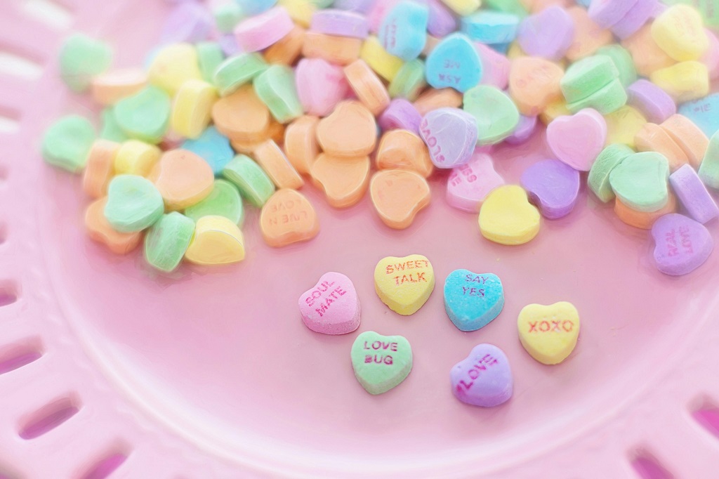 A bunch of conversation heart candies on a plate.