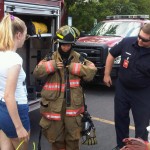 SU resident advisors try on firefighting gear with a helping hand from the Syracuse Fire Department as part of  the SU Fire Safety Academy.
