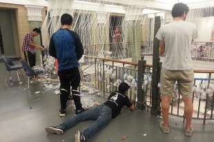 Students at work on the installation in Slocum Hall. School of Architecture students and faculty conceived and constructed this delicate web of dozens of lines of string blended into a structured, yet fragile, design.