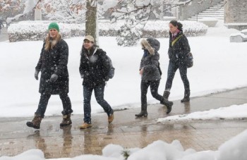 Students walk across campus during winter weather.+