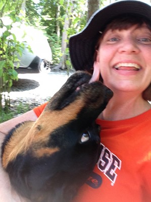 Barbara Jones, professor of practice at the Newhouse School, gets a kiss from her rottweiler.
