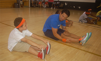 A member of Team Yoo works with a youngster during the annual "Bhealthy.Bfit.Bmore." event at Living Classrooms'Carmelo Anthony Youth Development Center in East Baltimore on July 26.
