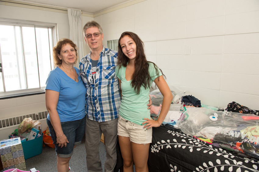 Family members settle a new student into her room. 