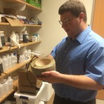 Lab Assistant Gary Bonomo holds a sand bath, which is used to heat glassware evenly.  
