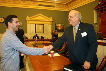 Dan Lang, left, a senior social work major, shakes hands with John Allen, special assistant to the commissioner, director, Office of Consumer Affairs, NYS Office of Mental Health, during the 16th Annual James L. Stone Legislative Policy Forum.