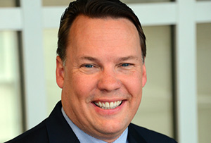 Man with dark hair smiling.