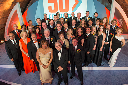 Newhouse Dean Lorraine Branham and Donald Newhouse, president of Advance Publications (front center) join the 50 alumni honorees for a group photo at the start of the event. In the second row (from left) are emcee Mike Tirico ’88 and spotlight honorees Tonia O’Connor ’91, Larry Kramer ’72, Rob Light ’78, Kitty Lun G’80 and Bob Costas ’74. 