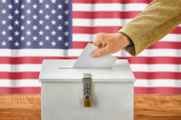 Man putting a ballot into a voting box - USA