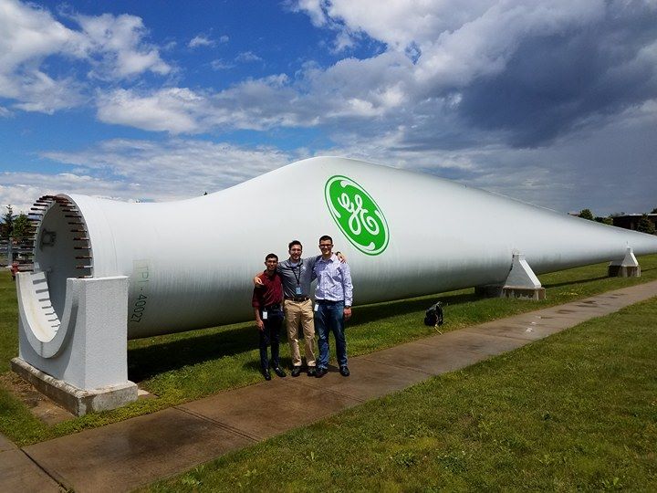 three men in front of turbine