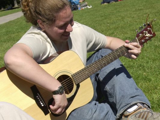 student playing guitar on the quad