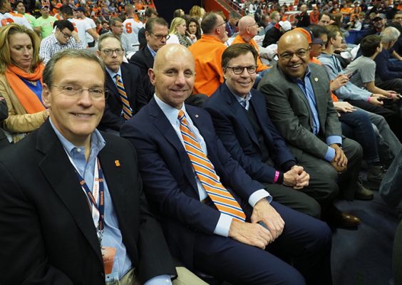 Enjoying Tuesday’s Syracuse-Iona men’s basketball game are (front row) Syracuse Director of Athletics John Wildhack ’80, Sean McDonough ’84, Bob Costas ’74 and Mike Tirico ’88, along with (second row) Beth Mowins G’90 and Sandy Montag ’85. (Photo by Michael J. Okoniewski)