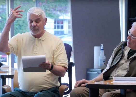 Veteran reads his writing while another looks on