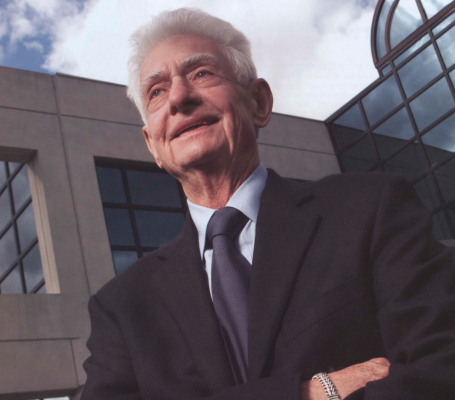 Joseph O. Lampe ’53, L’55 standing outside with blue sky and clouds in the background