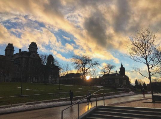 sun setting over campus buildings