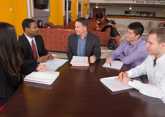 Professor and students meeting around a table