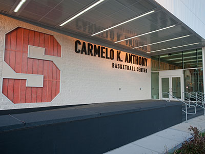 The entrance to the Melo Center on the right, with name running along wall, and big "S" on the left
