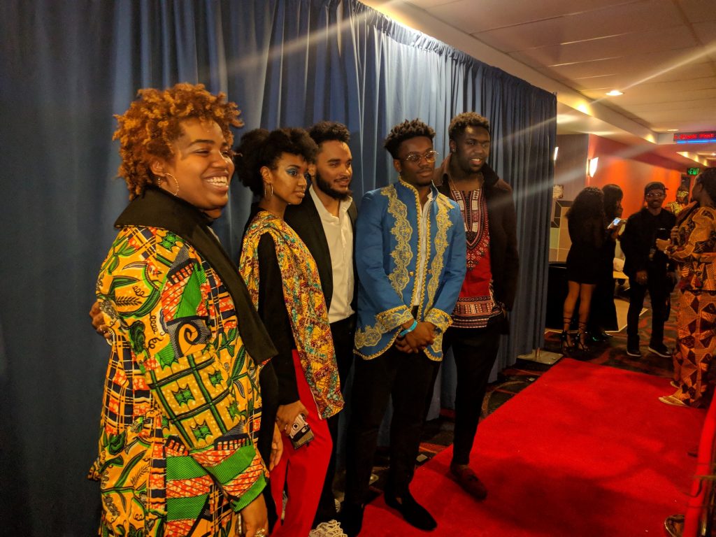 several people standing on red carpet