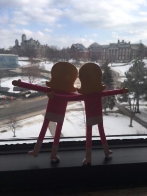 two art figures looking out window over campus