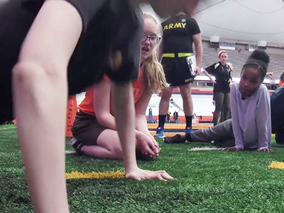 ROTC members doing pushups with youngsters watching