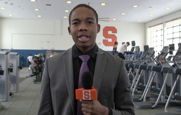 anthony haynie holding microphone inside womens building workout area.